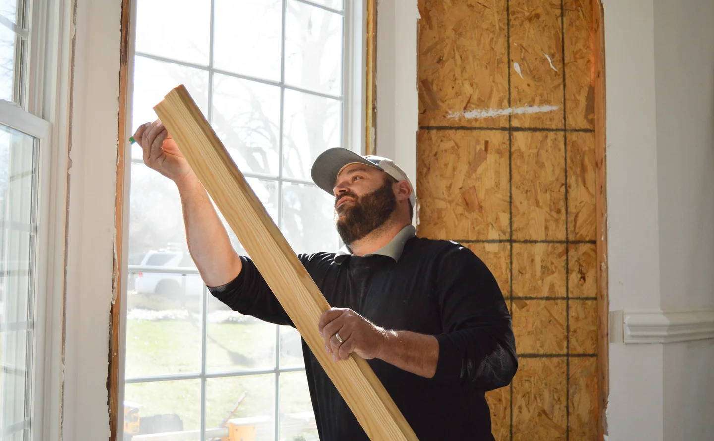 Man marking a board by a window