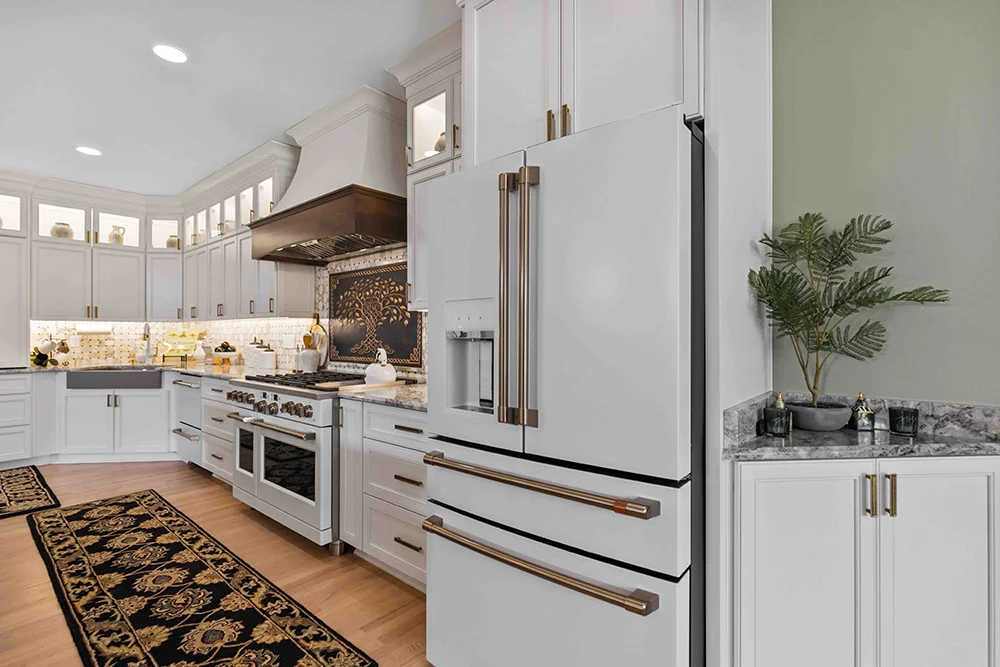 Custom kitchen with white cabinets bronze accents and hardwood floors