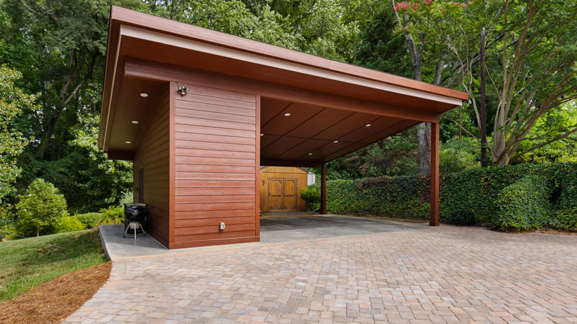 Modern brown carport inspired by Frank Lloyd Wright Architecture in a lush green backyard
