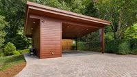 Modern brown carport inspired by Frank Lloyd Wright Architecture in a lush green backyard