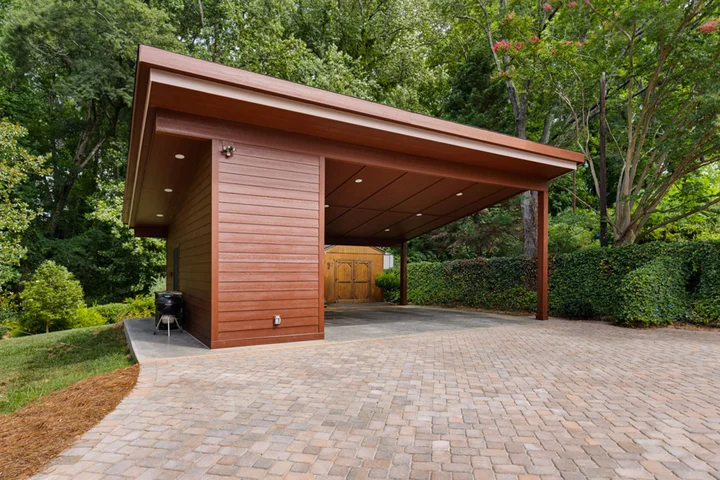 Modern brown carport inspired by Frank Lloyd Wright Architecture in a lush green backyard