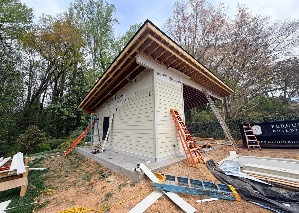 Custom carport in progress with fiber cement siding installation underway