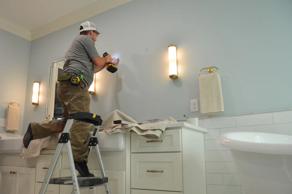 Behind the scenes: carpenter installing mirrors in bathroom